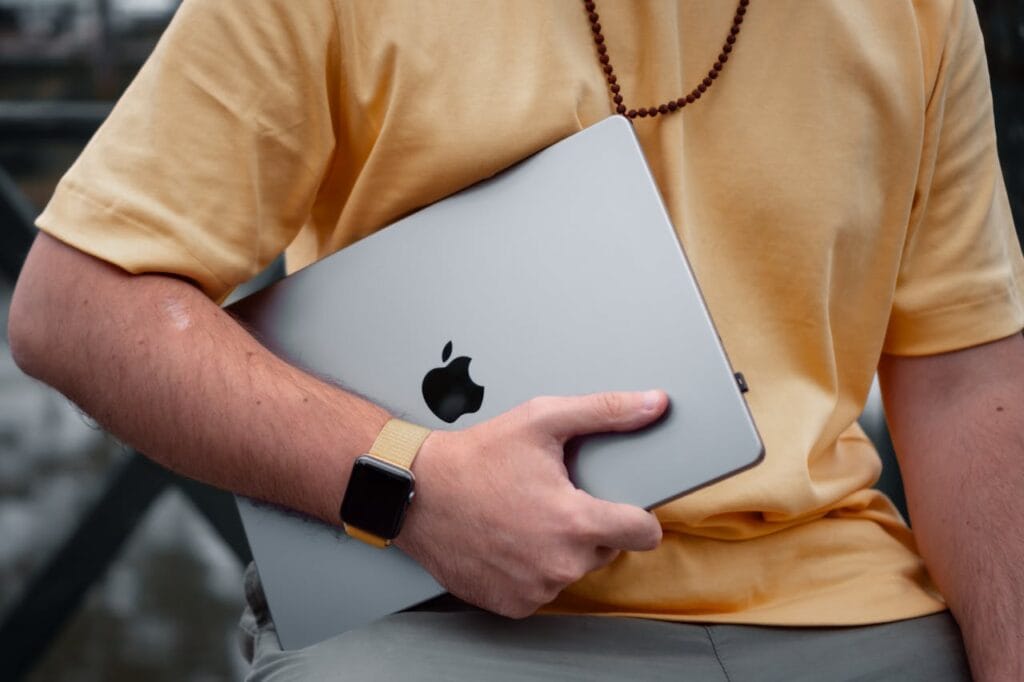 pexels-photo-17617348 A close-up of a man holding a laptop and wearing a smartwatch outdoors, reflecting modern lifestyle.