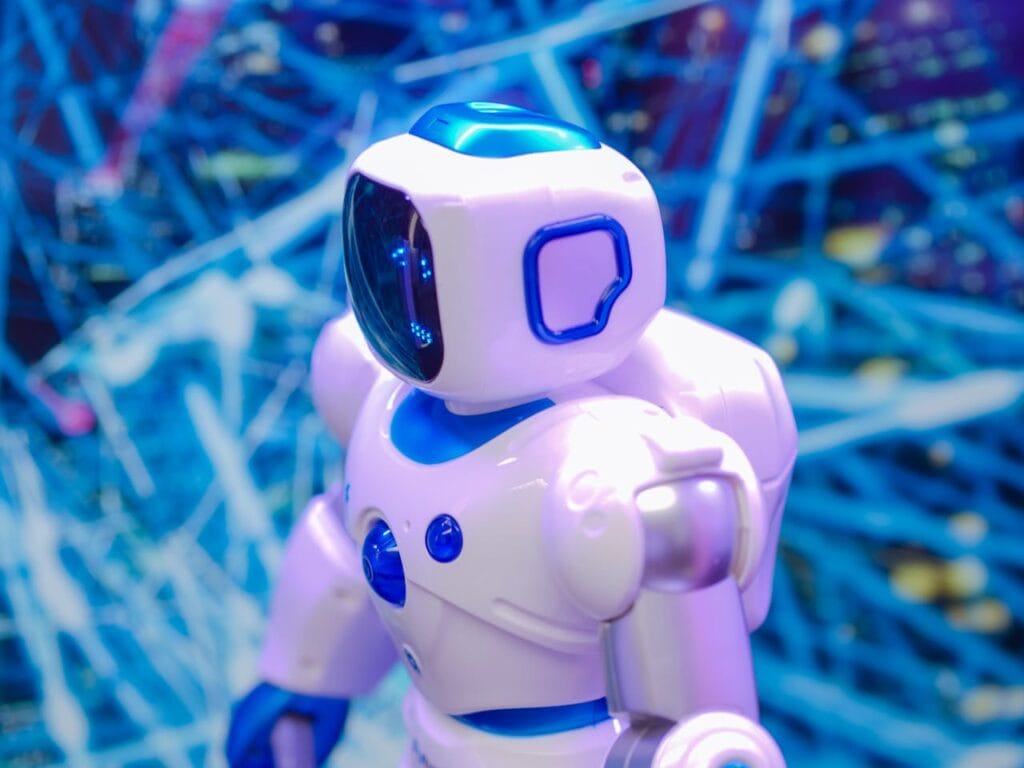 pexels-photo-8566464 Close-up of a white and blue robot against a dynamic, futuristic tech backdrop.